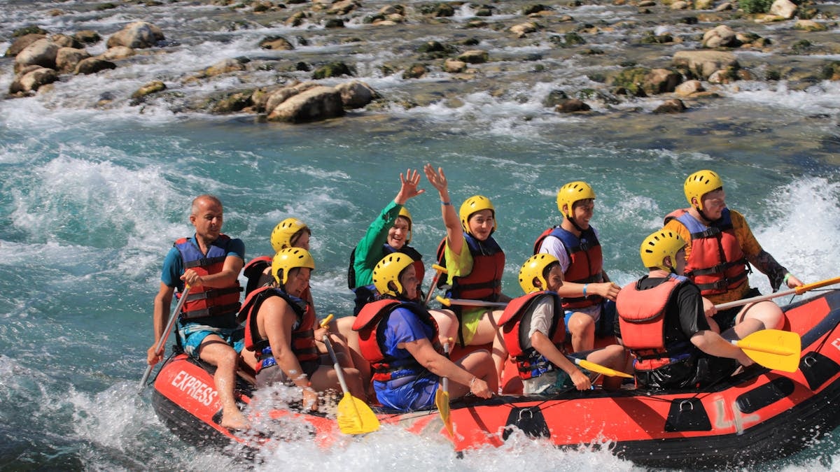 A group of adults enjoys an exciting whitewater rafting trip on a scenic river.